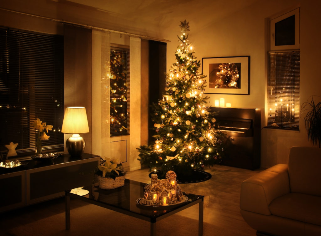 nice living room with white couch peaking in the corner and beautiful Christmas tree with white lights in the center